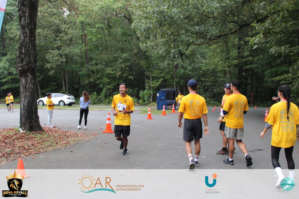 Royals Run participant finishing with volunteers nearby